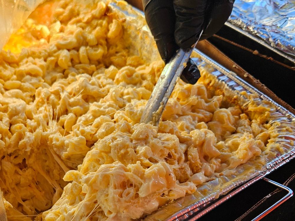 Baked macaroni and cheese being lifted from the pan